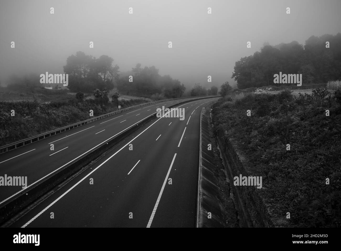 Eine leere Autobahn im Nebel. Schwarzweiß-Foto. Stockfoto