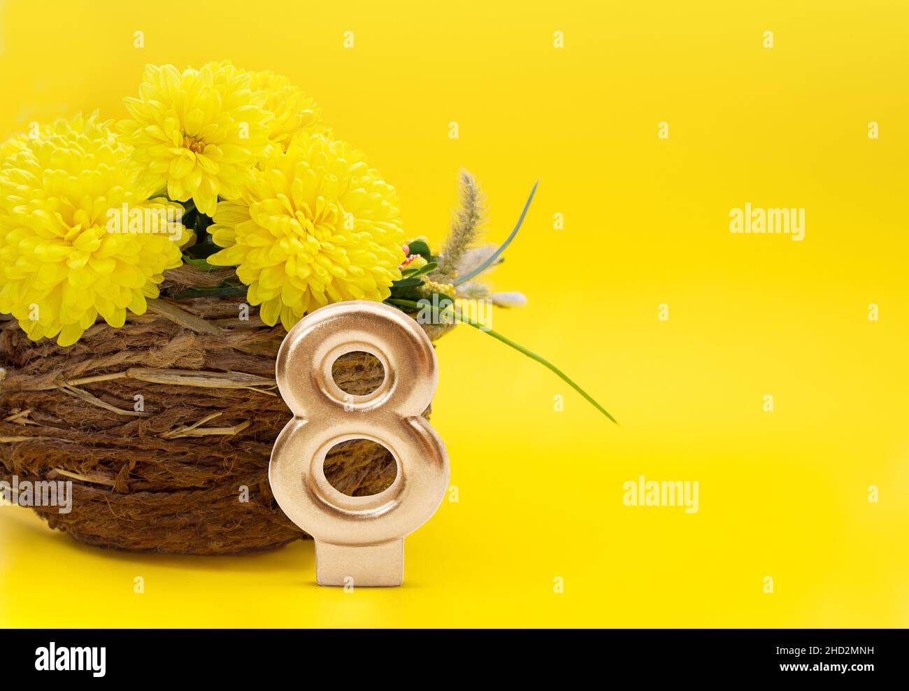 Strauß Chrysanthemen in einer Jutevase und Nummer 8 auf gelbem Grund. Geschenk zum Internationalen Frauentag, 8. März, Geburtstag. Speicherplatz kopieren Stockfoto