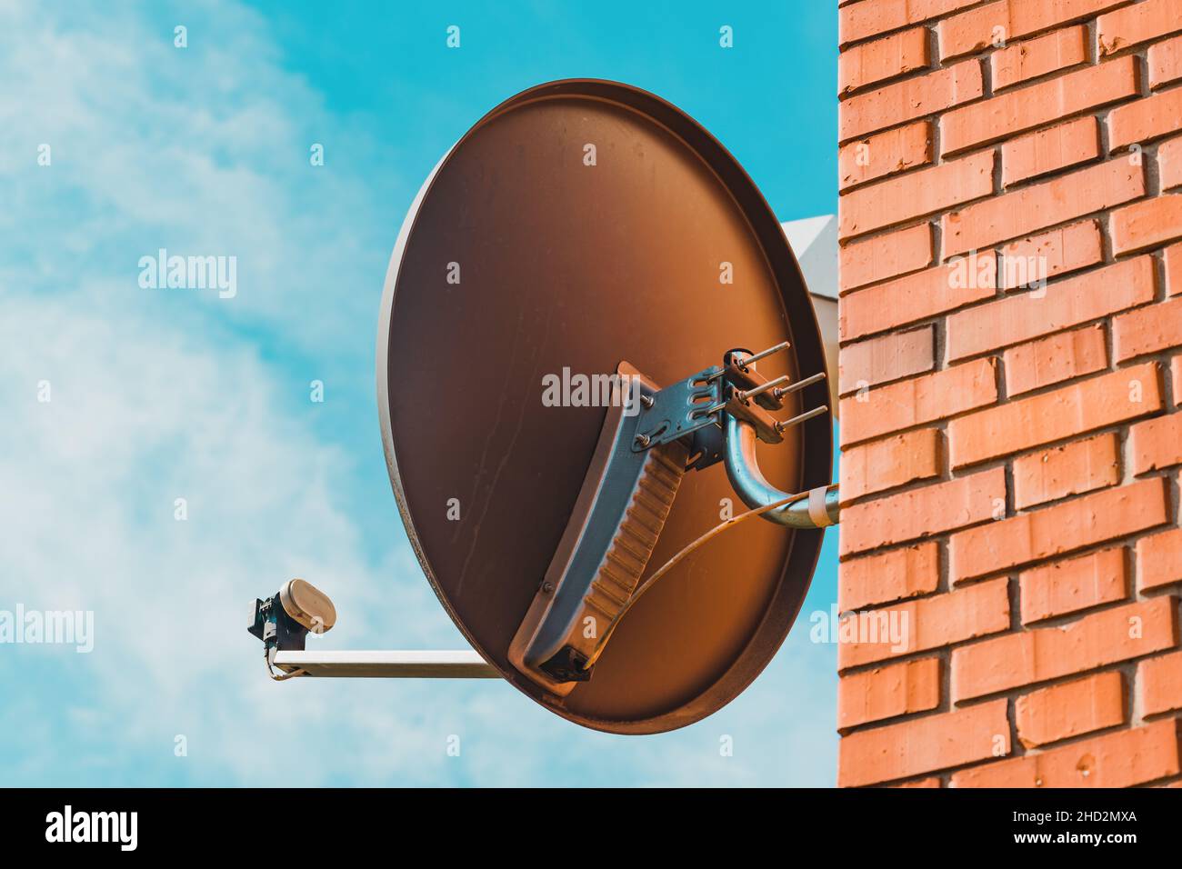 Alte Satellitenschüssel auf Haussteinmauer montiert, selektiver Fokus Stockfoto