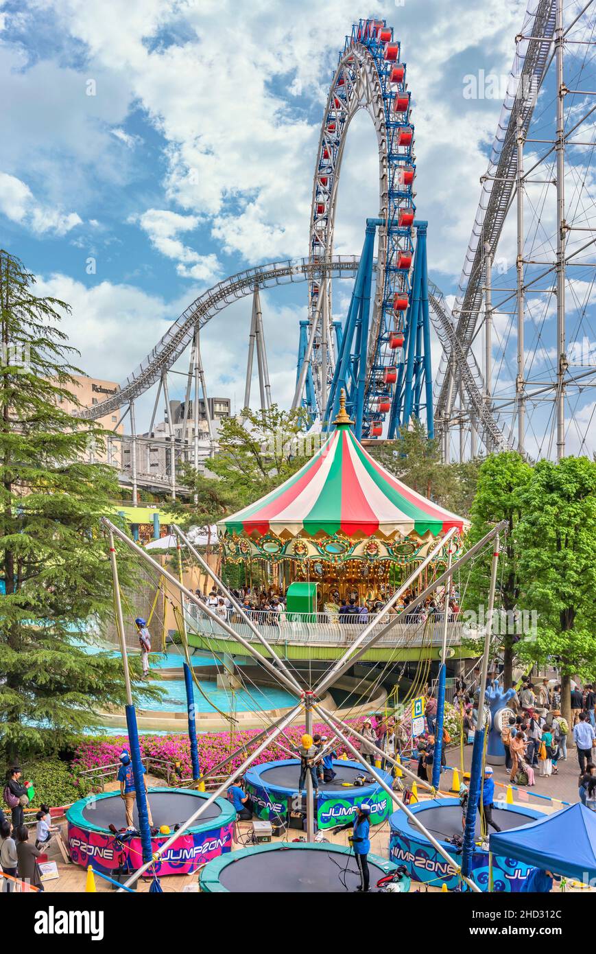 tokio, japan - Mai 03 2019: Familien genießen Trampolin und Karussell in der Laqua Tokyo Dome City Mall, die von der Stahlachterbahn Thunder Dolphin überblickt wird Stockfoto