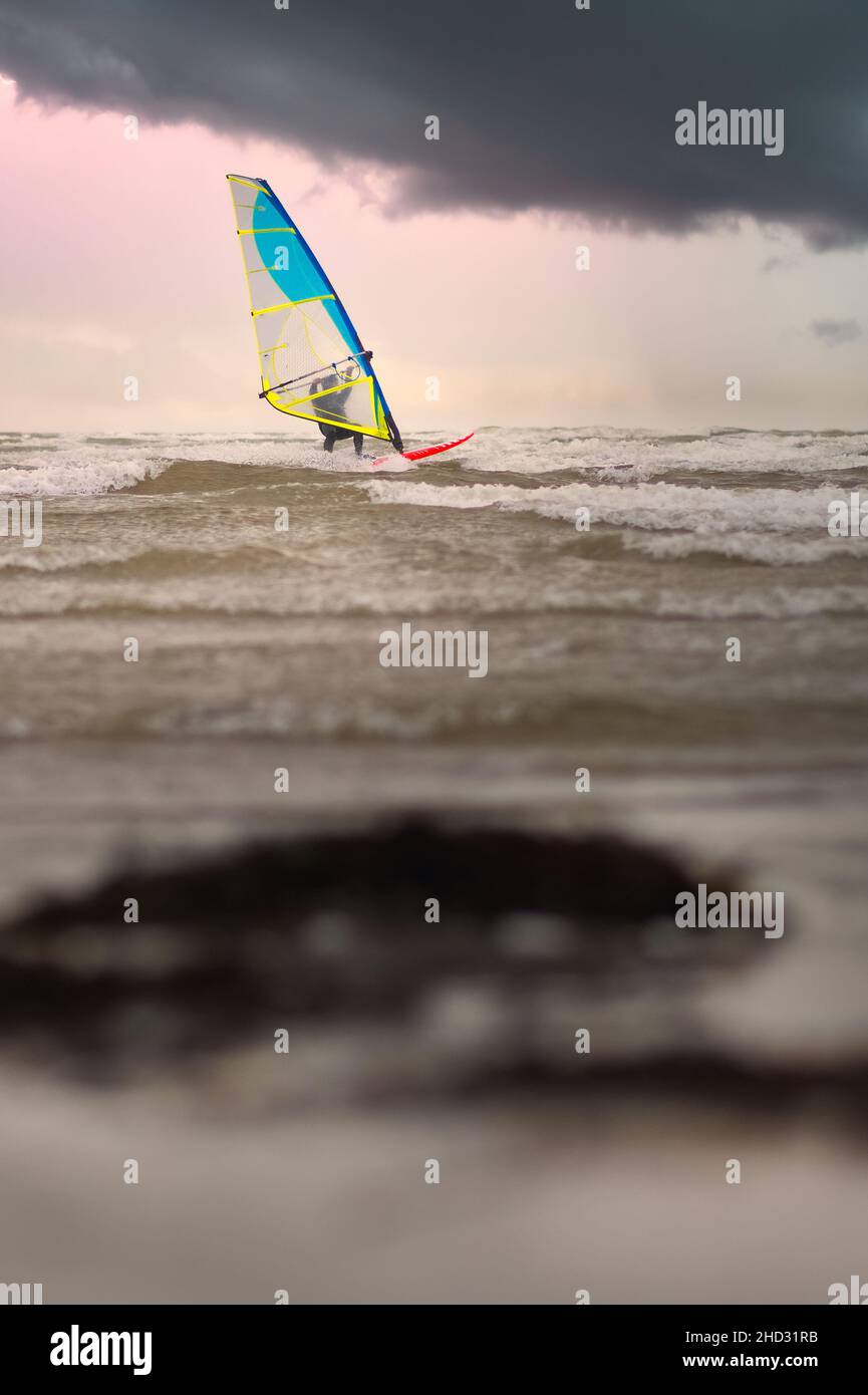 Surfer unter dramatisch bewölktem Himmel am Silver Strand in Galway, Irland Stockfoto