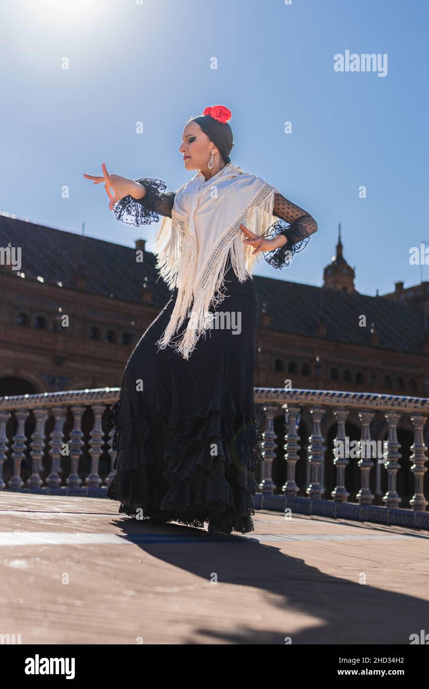 Flamenco-Tänzerin, die von der Sonne beleuchtet wird, während sie im Freien tanzt Stockfoto