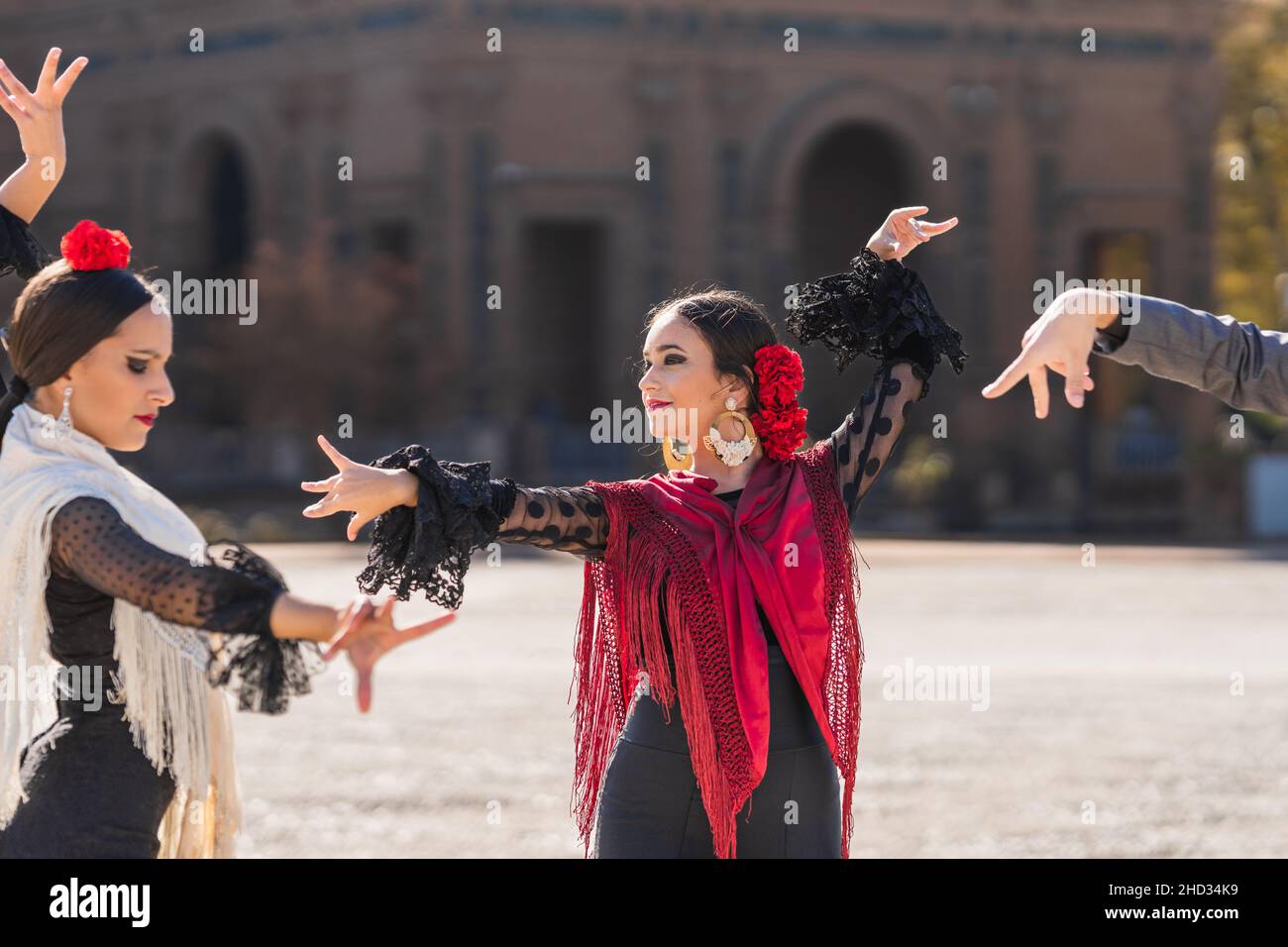 Drei Personen tanzen Flamenco in traditionellen Kostümen auf einem Platz Stockfoto
