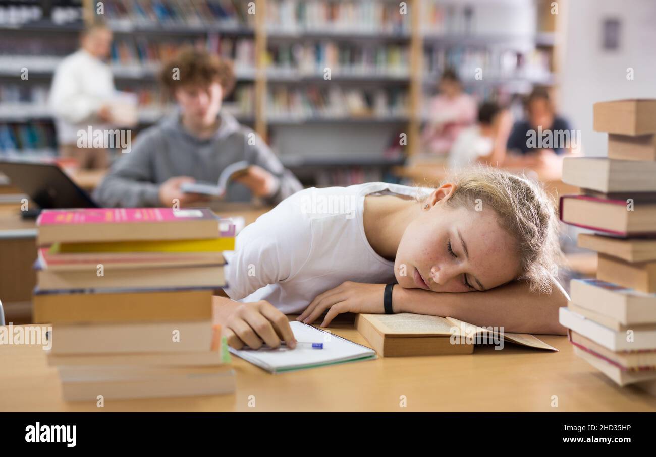 Müde Teenager Mädchen in der Bibliothek Stockfoto