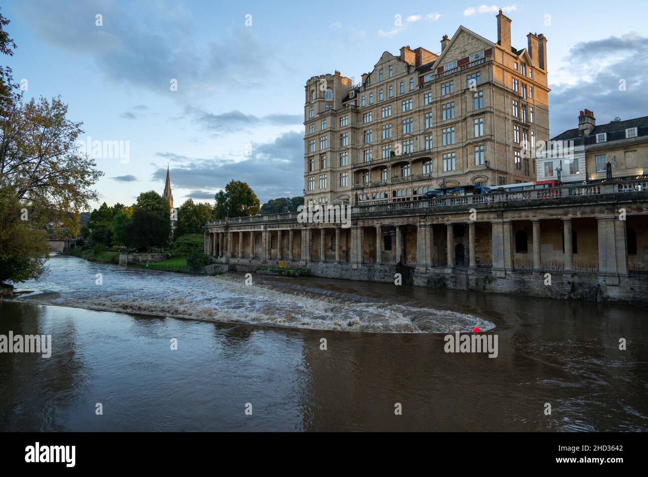 Das Empire Hotel und die Grand Parade Kolonnade, die sich über dem Fluss Avon Wehr in der historischen Weltkulturerbestätte Bath, Somerset, England, erhebt Stockfoto