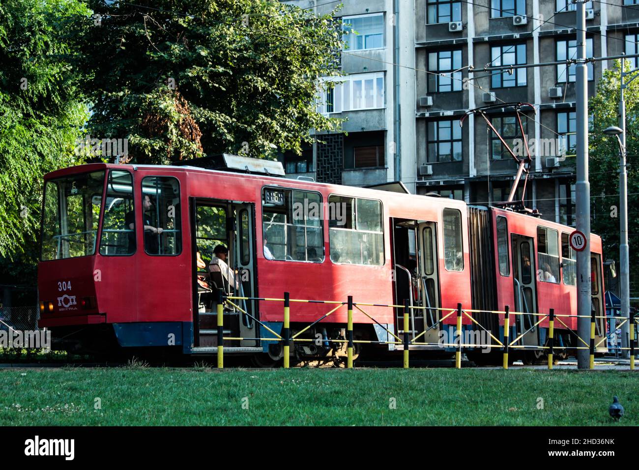 Rote Straßenbahn auf den Gleisen an einem sonnigen Tag in Belgrad, Serbien Stockfoto