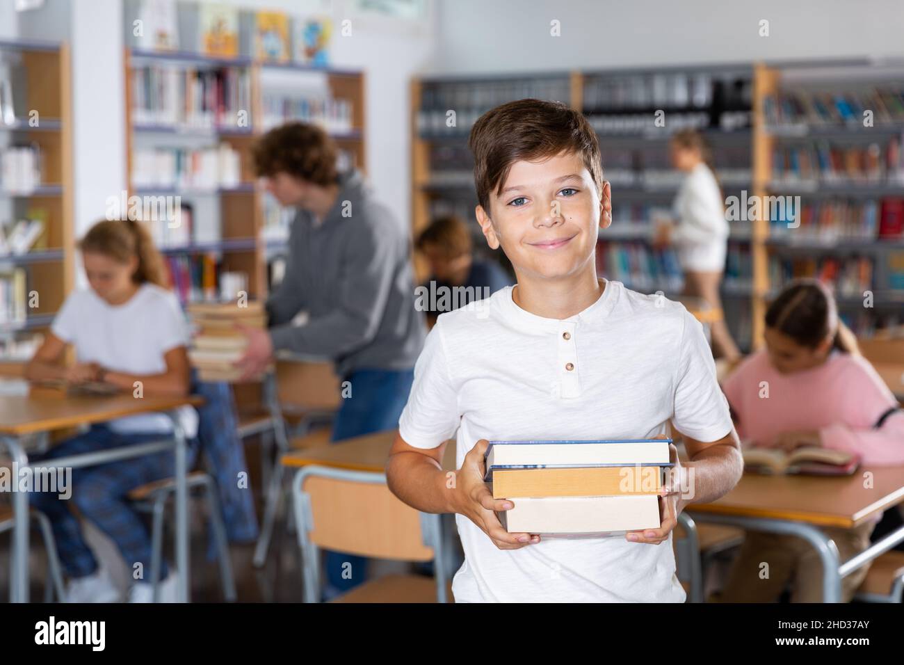 Porträt eines zehnjährigen Schuljungen, der Lehrbücher hält Stockfoto