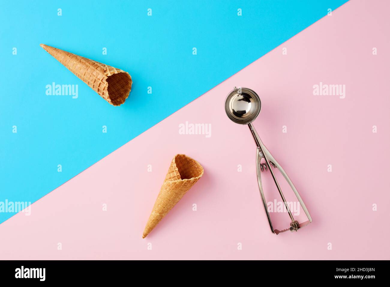 Eiszapfen mit Schaufel auf pastellrosa und blauem Hintergrund. Minimales sommerliches Essenskonzept. Flach liegend. Stockfoto