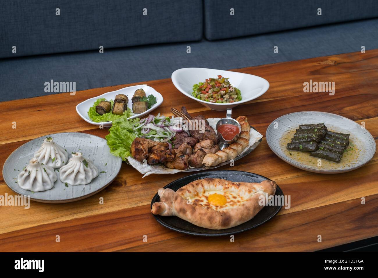 Festliches Fest mit verschiedenen Gerichten aus Georgien, Armenien und Russland. Kaukasische Küche. Verschiedene leckere Gerichte auf dem Holztisch. Stockfoto