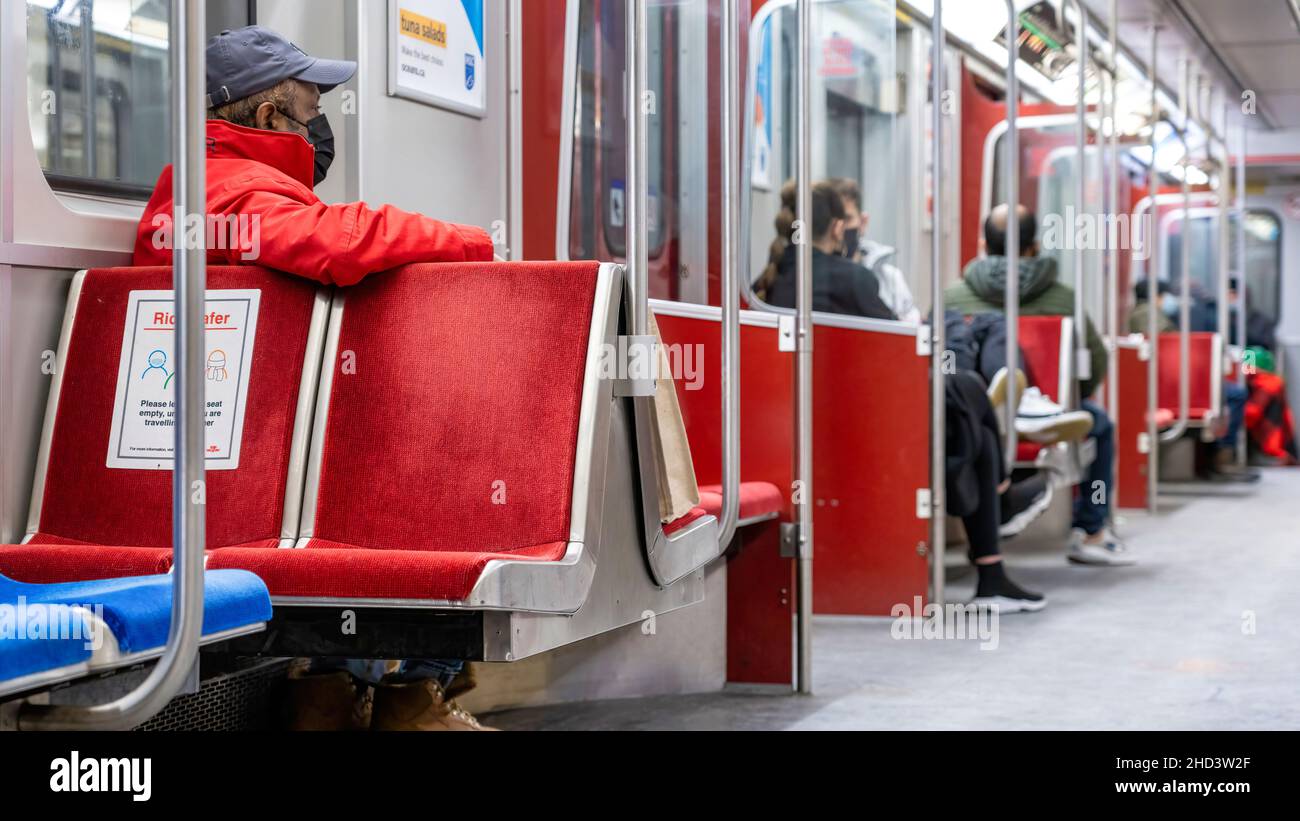Menschen mit schützenden Gesichtsmasken, während sie mit dem U-Bahn-Zug der Toronto Transit Commission (TTC) fahren. Januar 3, 2022 Stockfoto