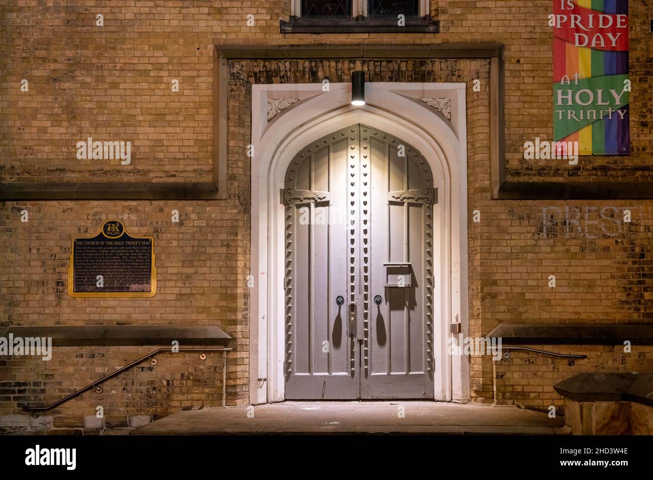 Alte Eingangstür beleuchtet in der Nacht in der Kirche der Heiligen Dreifaltigkeit. Links im berühmten Gebäude ist eine Gedenktafel zu sehen. Januar 3, 2022 Stockfoto