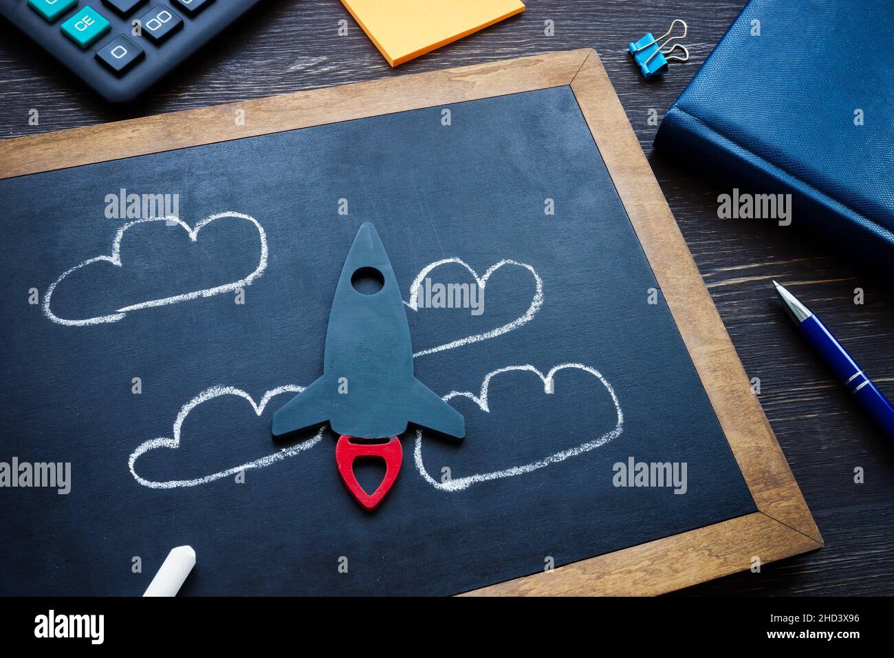 Kleine Rakete und gezeichnete Wolken als Symbol für Träume und neue Ideen in der Wirtschaft. Stockfoto