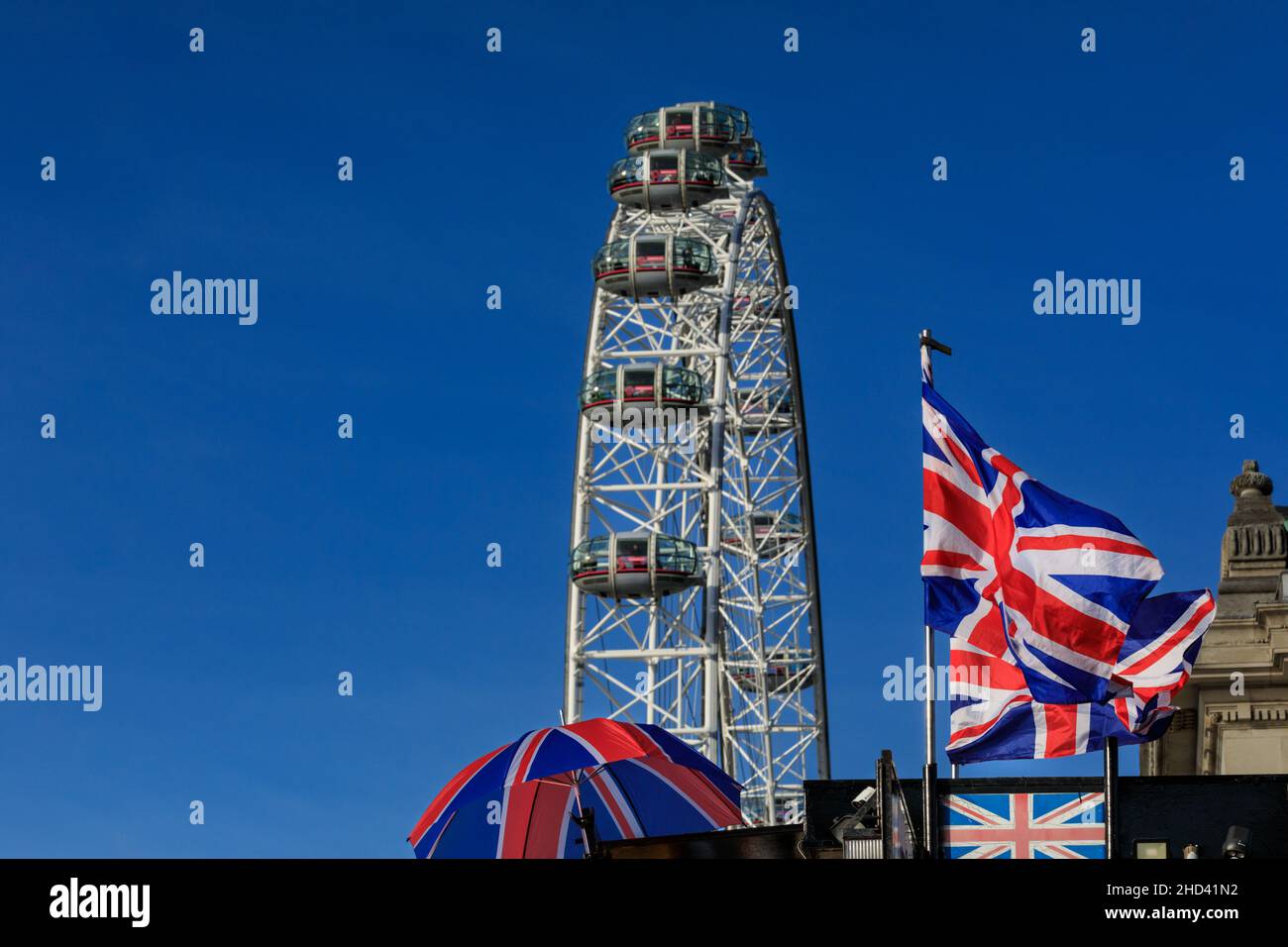 British Union Jack Flags mit dem London Eye Riesenrad gegen blauen Himmel, Tourist London, England, Vereinigtes Königreich Stockfoto