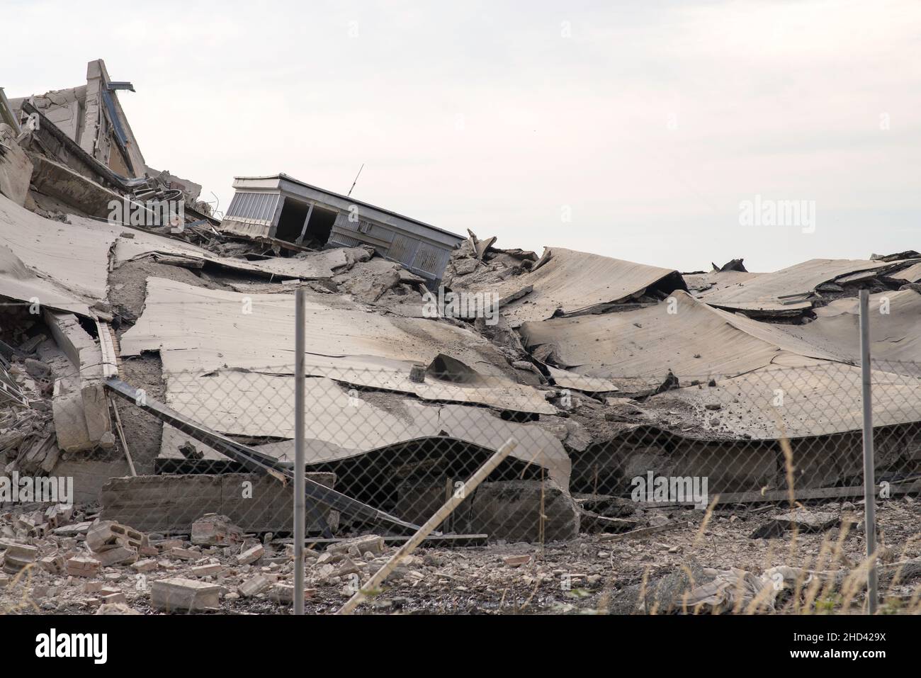 Industriebetongebäude durch Streik zerstört. Katastrophenereignis voller Trümmer, Staub und zerschmetterten Gebäuden. Stockfoto