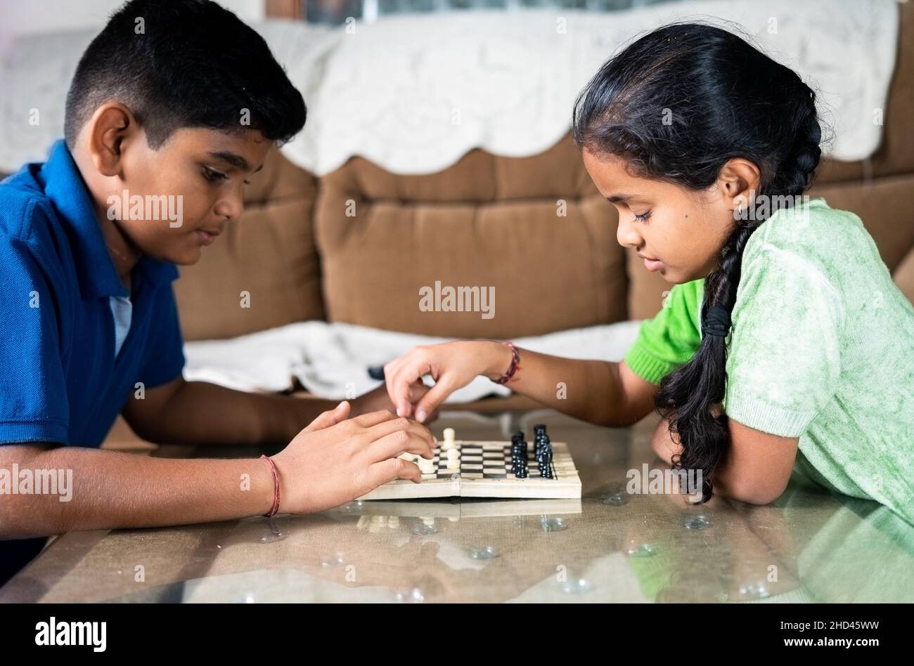 Konzentrieren Sie sich auf Mädchen, konzentrierte Geschwister Kinder beschäftigt spielen Schach zu Hause - Konzept der Kindheit geistige Entwicklung, Gameplay und Unterhaltung Stockfoto