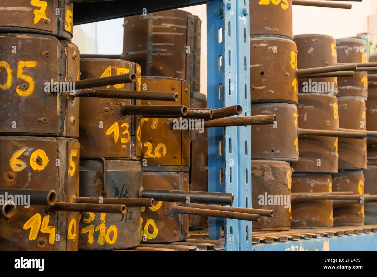 In der Fabrik oder Glasherstellung liegen Metallformen für die Herstellung verschiedener Formen von Glasprodukten auf den Regalen. Stockfoto