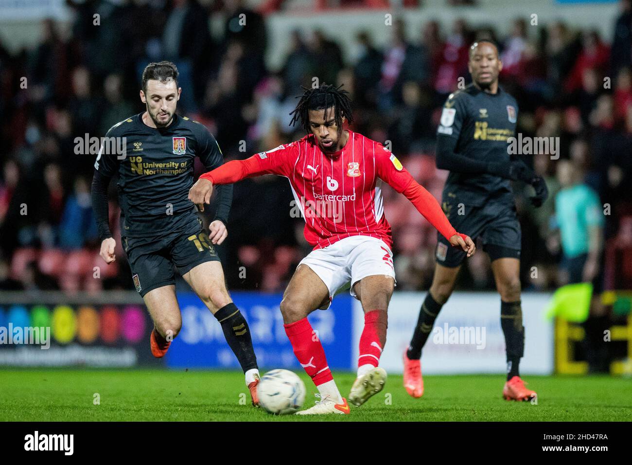 Akinwale Odimayo von Swindon Town (rechts) gewinnt den Ball gegen Dylan Connolly von Northampton Town (links) im zweiten Spiel der Sky Bet League auf dem County Ground, Swindon. Bilddatum: Samstag, 1. Januar 2022. Stockfoto