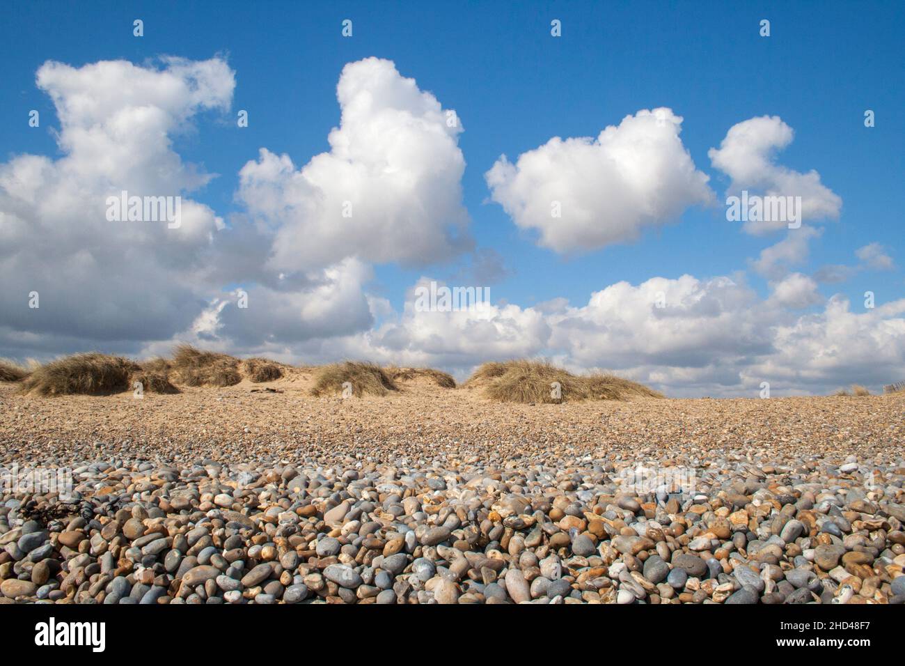 Flauschige weiße Wolken ziehen über Walberswick Beach, Suffolk, England Stockfoto