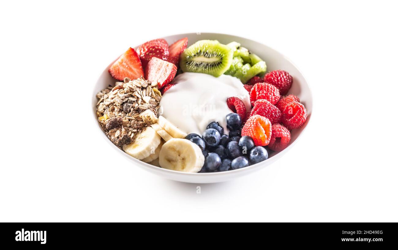 Obst- und Joghurtschüssel mit Müsli, Kiwi, Erdbeeren, Banane, Blaubeeren und Himbeeren auf isoliertem weißem Hintergrund. Stockfoto
