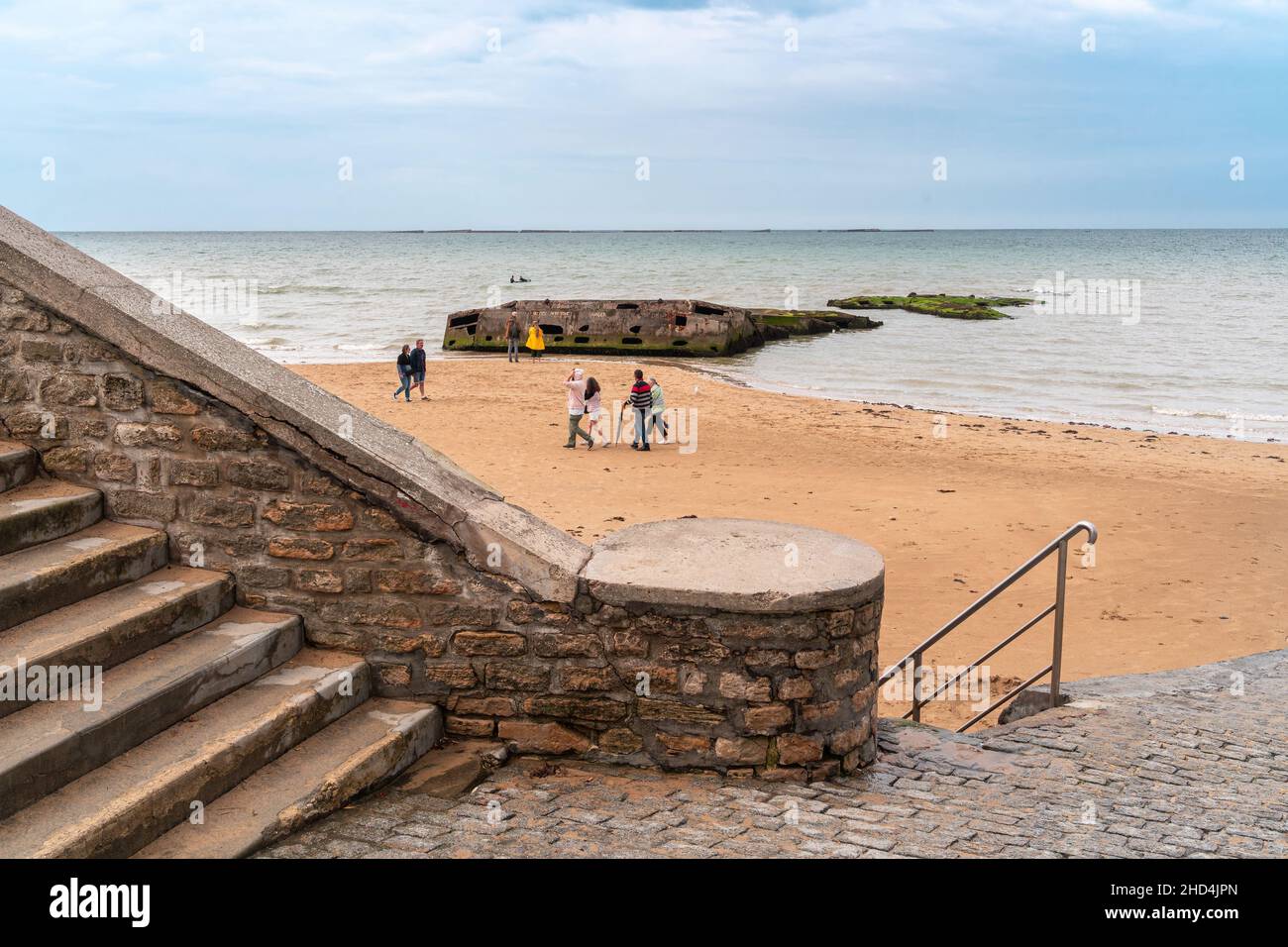 Arromanches, Frankreich - 2. August 2021: Treppe zum Strand mit militärischem künstlichen Hafen aus dem Weltkrieg und Landung von Verbündeten in Arromanches Nor Stockfoto