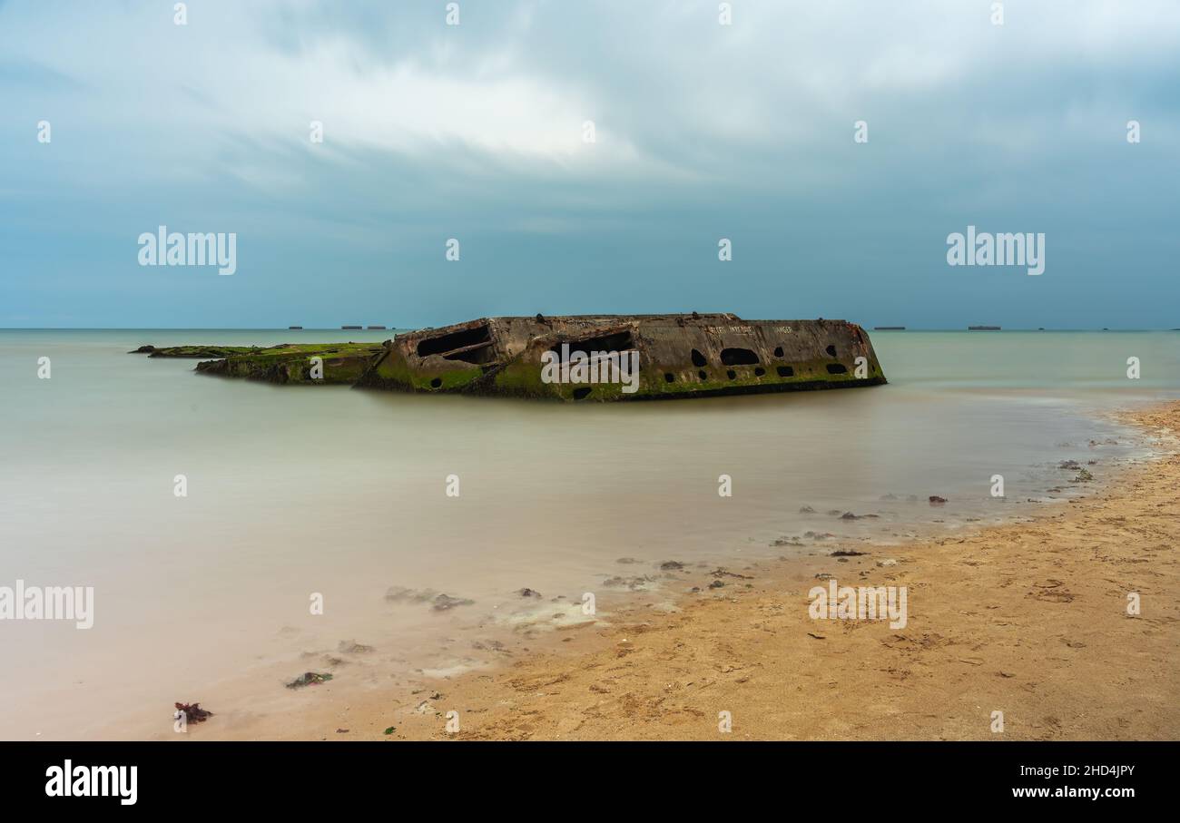 Arromanches, Frankreich - 2. August 2021: Überreste eines künstlichen militärischen Landungshafens in Arromanches in der Normandie - Langzeitbelichtung Stockfoto