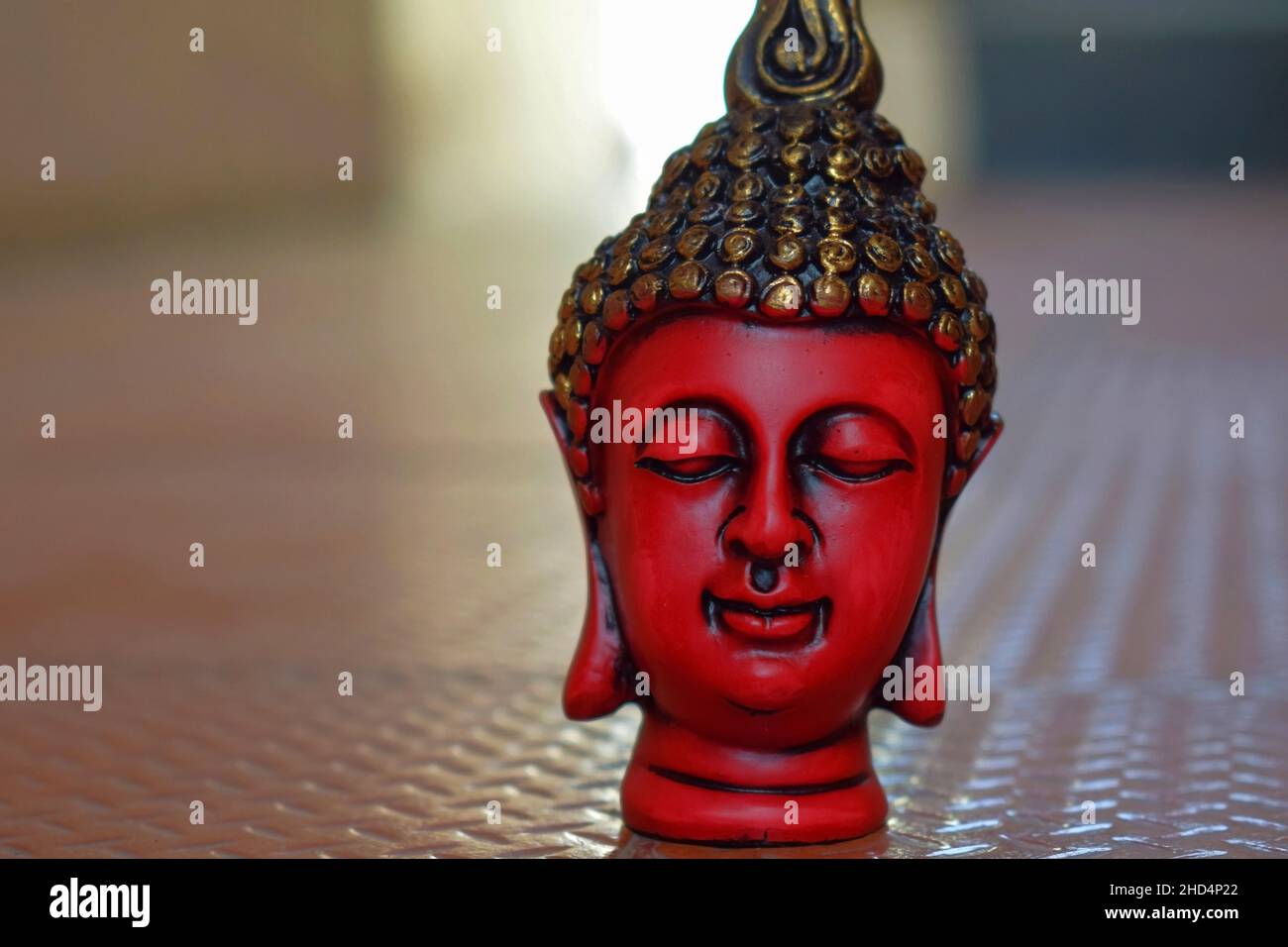 Stock Foto von schönen roten Farbe Gesicht Skulptur oder Statue von lord buddha, Kopf der Statue mit schwarzer und goldener Farbe auf brauner Farbe backgrou gemalt Stockfoto