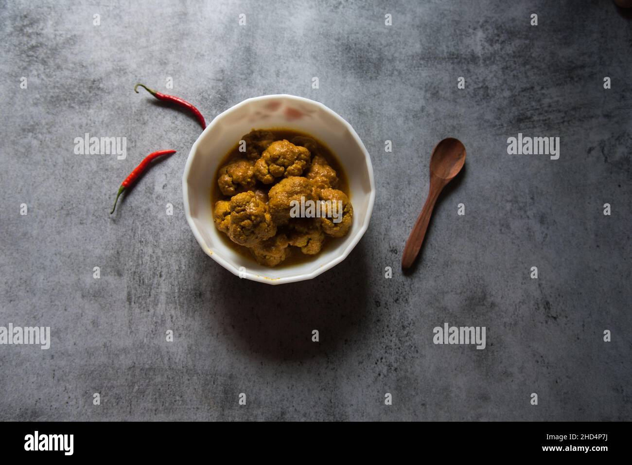 Gobi Masala, ein gerösteter Blumenkohl oder ein Schälchen, serviert in einer weißen Schüssel. Draufsicht. Stockfoto