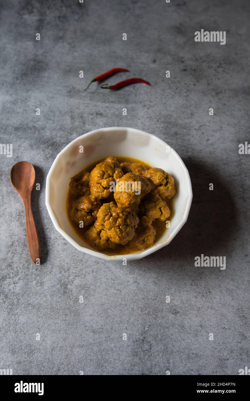 Gobi Masala, ein gerösteter Blumenkohl oder ein Schälchen, serviert in einer weißen Schüssel. Draufsicht. Stockfoto
