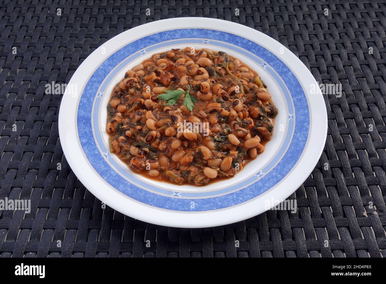 Schwarze Erbsen mit Tomatensauce Spinat und anderem Gemüse. Mavromatika Fafolia griechische Küche. Stockfoto Schwarze Erbsen mit Tomatensauce Spinat und anderem Gemüse. Mavromatika Fafolia griechische Küche. Stockfoto