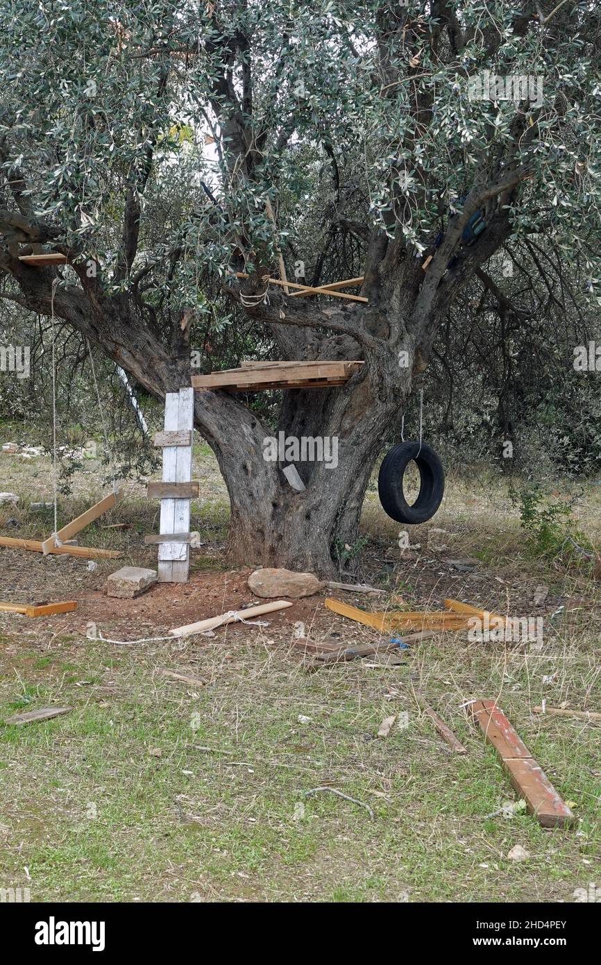 Baumhaus von Kindern mit provisorisch hölzernen Leiter und Schaukeln gebaut. Stockfoto