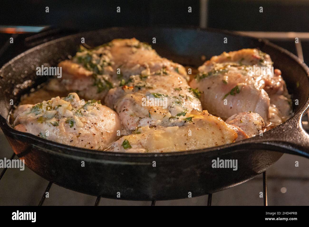 Nahaufnahme des Hähnchens, das in einer gusseisernen Pfanne gekocht wird Stockfoto