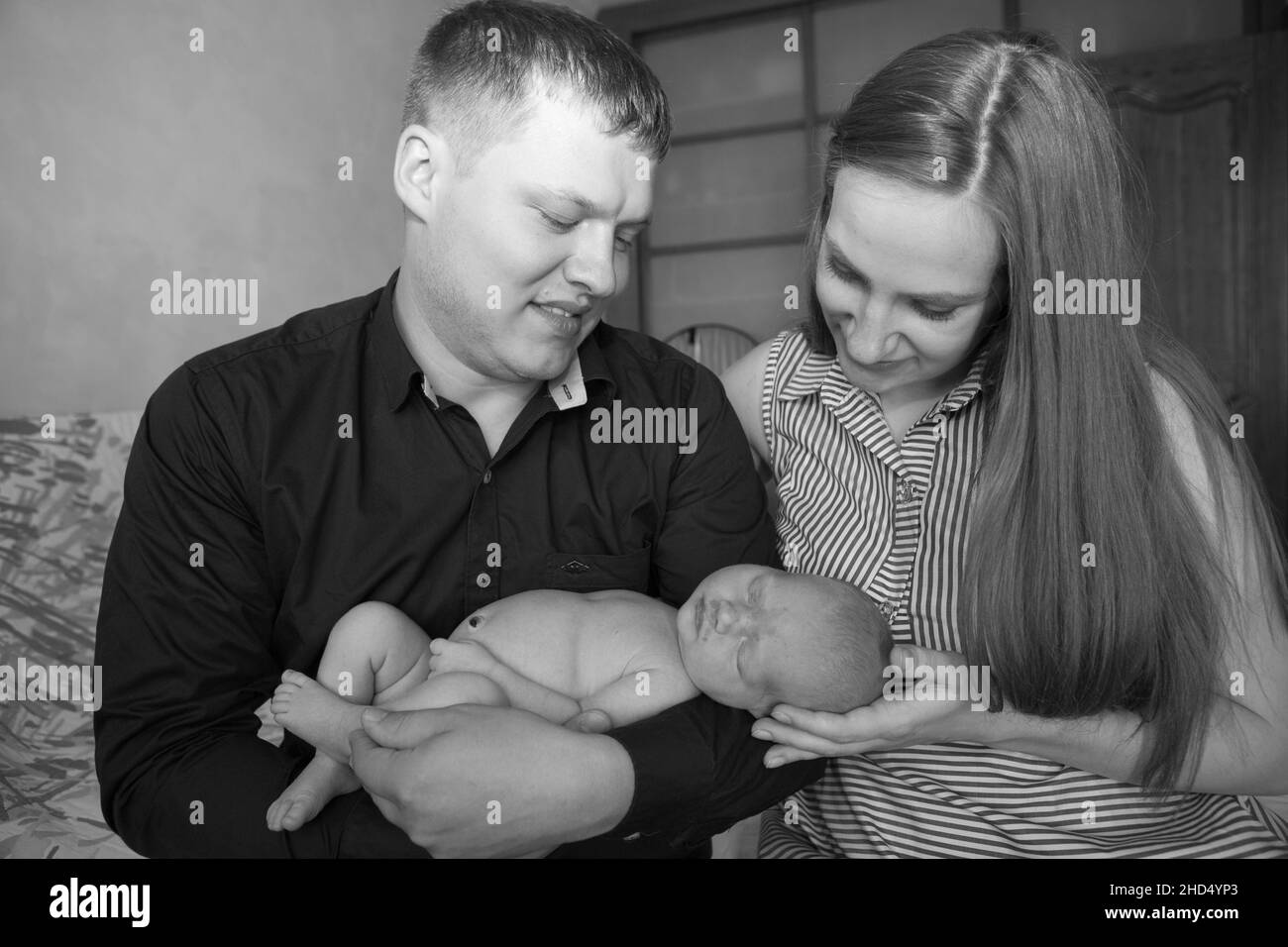 Portrait von attraktiven fröhlichen Lebenspartner Papa Mama niedliches Baby. Vertrauen Sie der süßen Zeit zuhause. Stockfoto