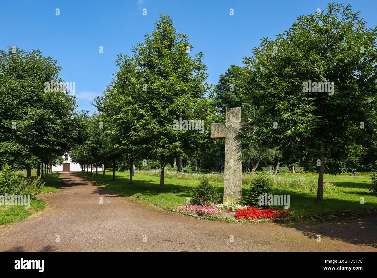 Marl, Nordrhein-Westfalen, Deutschland - Gedenksteinkreuz, hinter dem Europäischen Friedenshaus, ehemalige Friedhofskapelle im Friedenspark, das Alte Kem Stockfoto