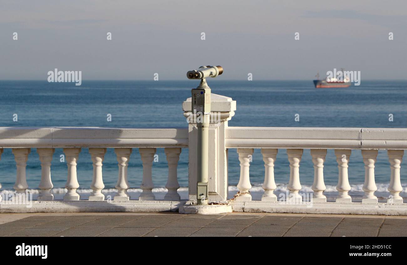 Münzbetriebenes Metall Tower Viewer Fernglas auf einem Stiel am Meer mit Blick auf das Meer auf einem verankerten Schiff Sardinero Santander Cantabria Spanien Stockfoto