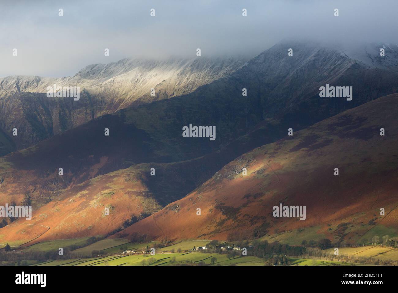 Blencathra Berg im englischen Lake District im Winterlicht mit Schnee auf den Gipfeln. Niedrige Wolke auf den Gipfeln und strahlte Licht auf den Pisten. Stockfoto