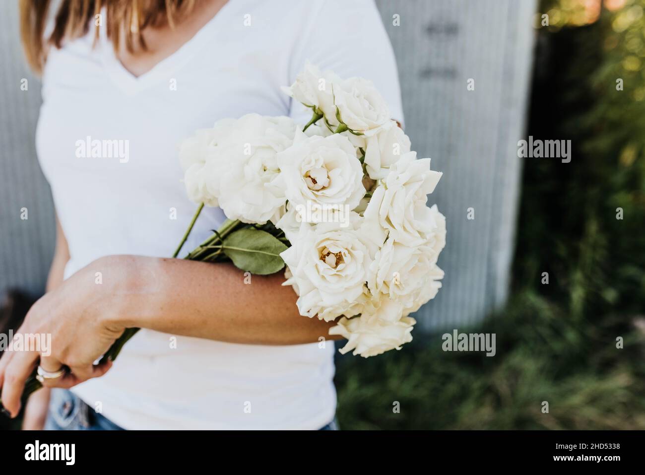 Nahaufnahme der Frau hält Strauß von weißen Rosen in den Arm Stockfoto