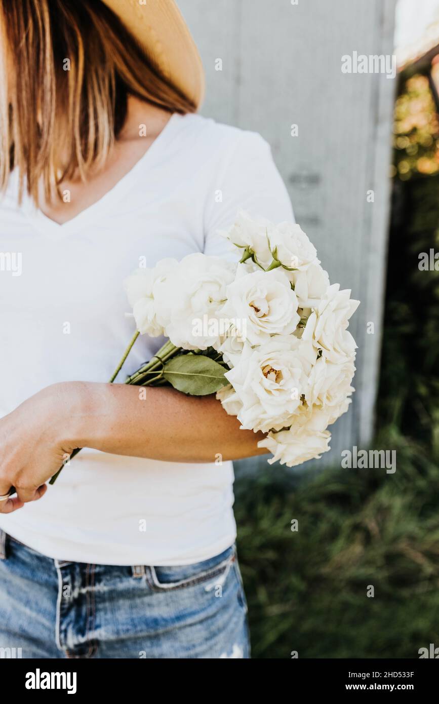 Nahaufnahme der Frau hält Strauß von weißen Rosen in den Arm Stockfoto