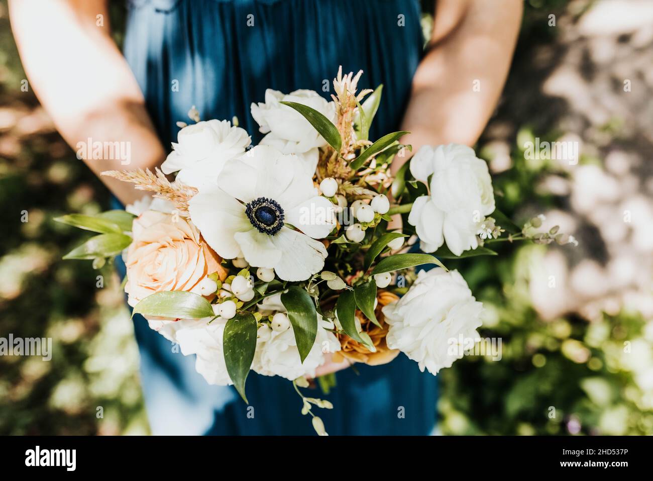 Ein Blumenstrauß aus weißem, rosa und blauem Blumenstrauß über dem Kopf Stockfoto