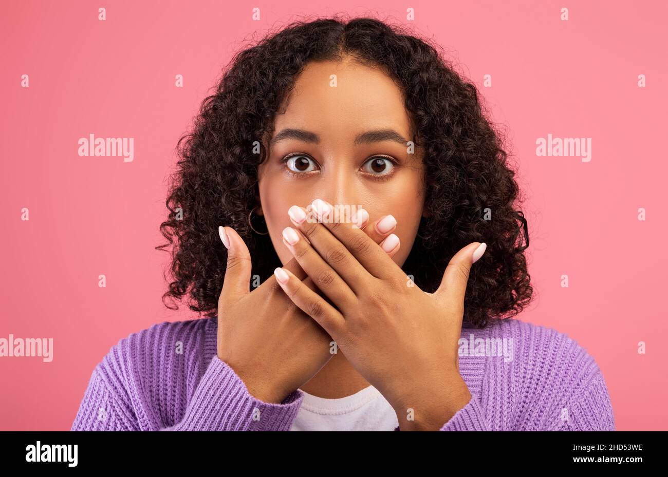 Hoppla. Verblüffte junge afroamerikanische Frau, die den Mund mit Händen bedeckt, schockiert von Nachrichten oder Angeboten auf rosa Hintergrund Stockfoto