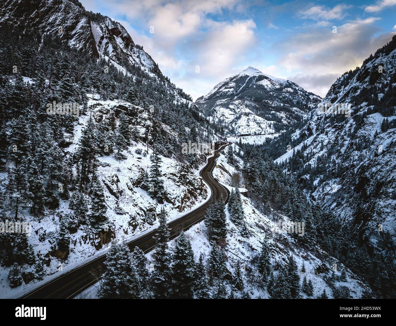 Verschneite Straße schlängelt sich durch Berge, Red Mountain Pass, Colorado Stockfoto