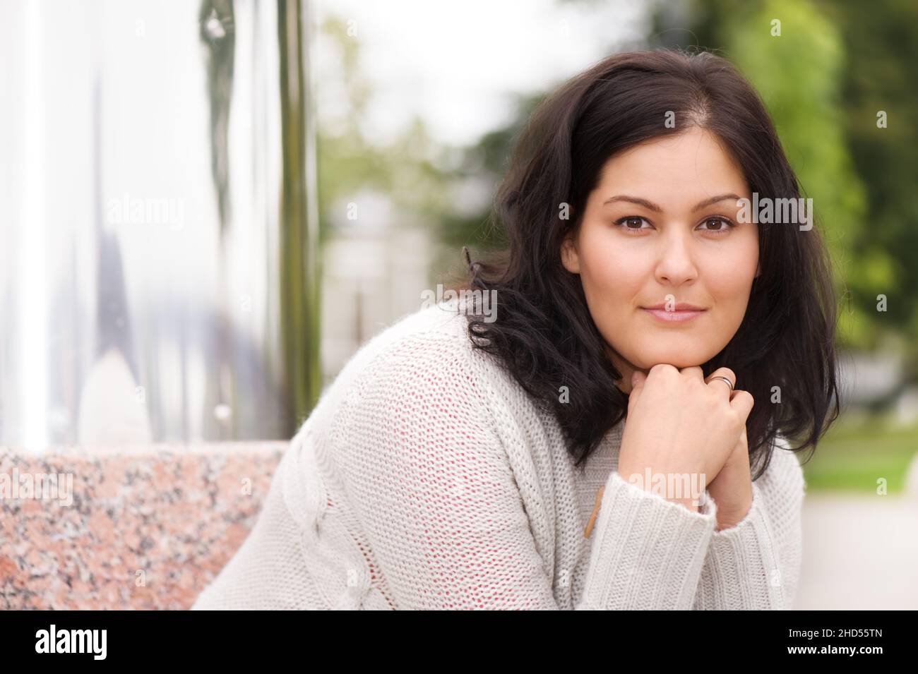 Schöne junge Frau, die die Kamera anschaut. Selektiver Fokus und geringe Schärfentiefe. Stockfoto