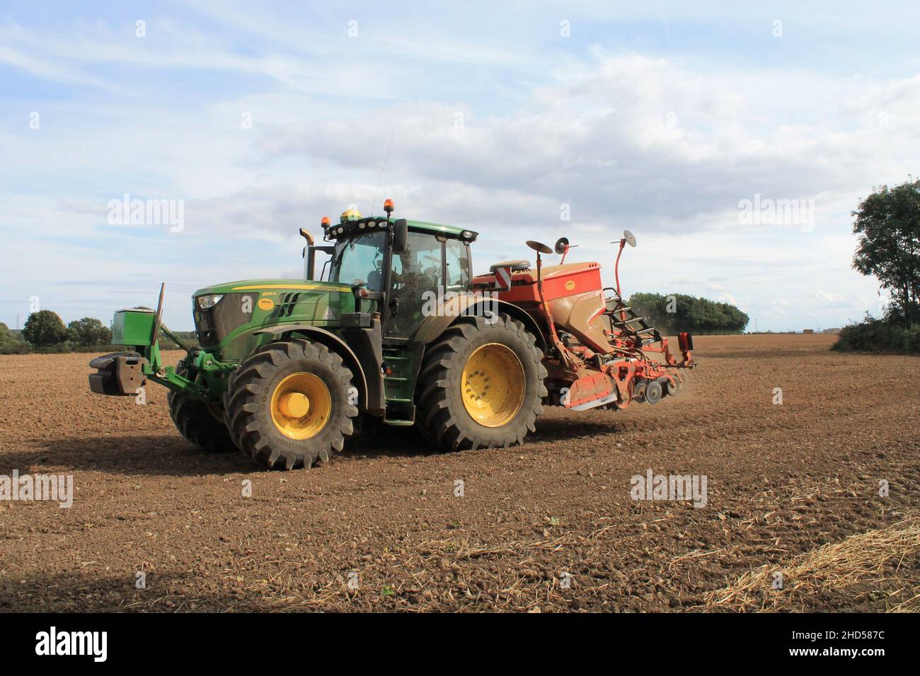 Garforth in der Nähe von Leeds West Yorkshire, Großbritannien 18th. Juli 2021 Bauer pflügt und sät ein Feld mit Traktor und Sämaschine an einem Sommermorgen Stockfoto