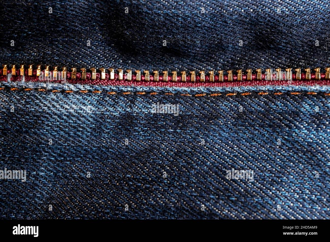 Goldfarbener Reißverschluss an den Details der Denim-Kleidung aus nächster Nähe. Stockfoto