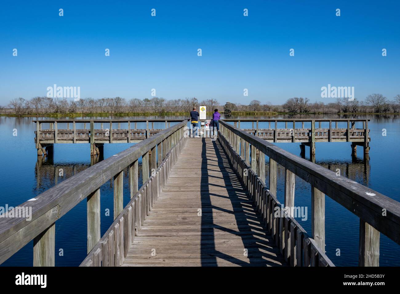 Zwei Männer fischen auf dem Pier am 40 Acre Lake. Brazos Bend State Park. Needville, Texas, USA. Stockfoto