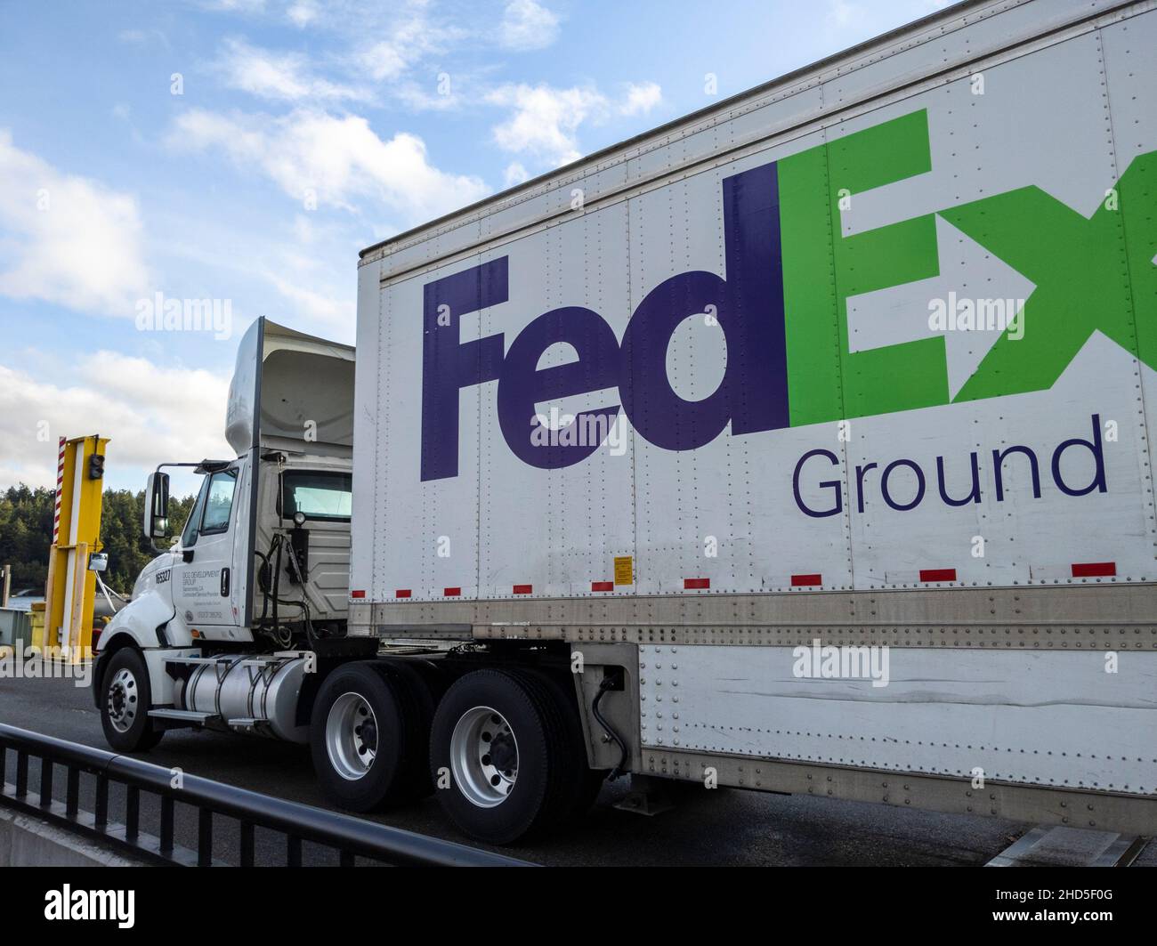 Friday Harbor, WA USA - ca. November 2021: Blick auf einen FedEx-Güterwagen, der an einem hellen, sonnigen Tag an einer Washington State Ferry anfährt. Stockfoto