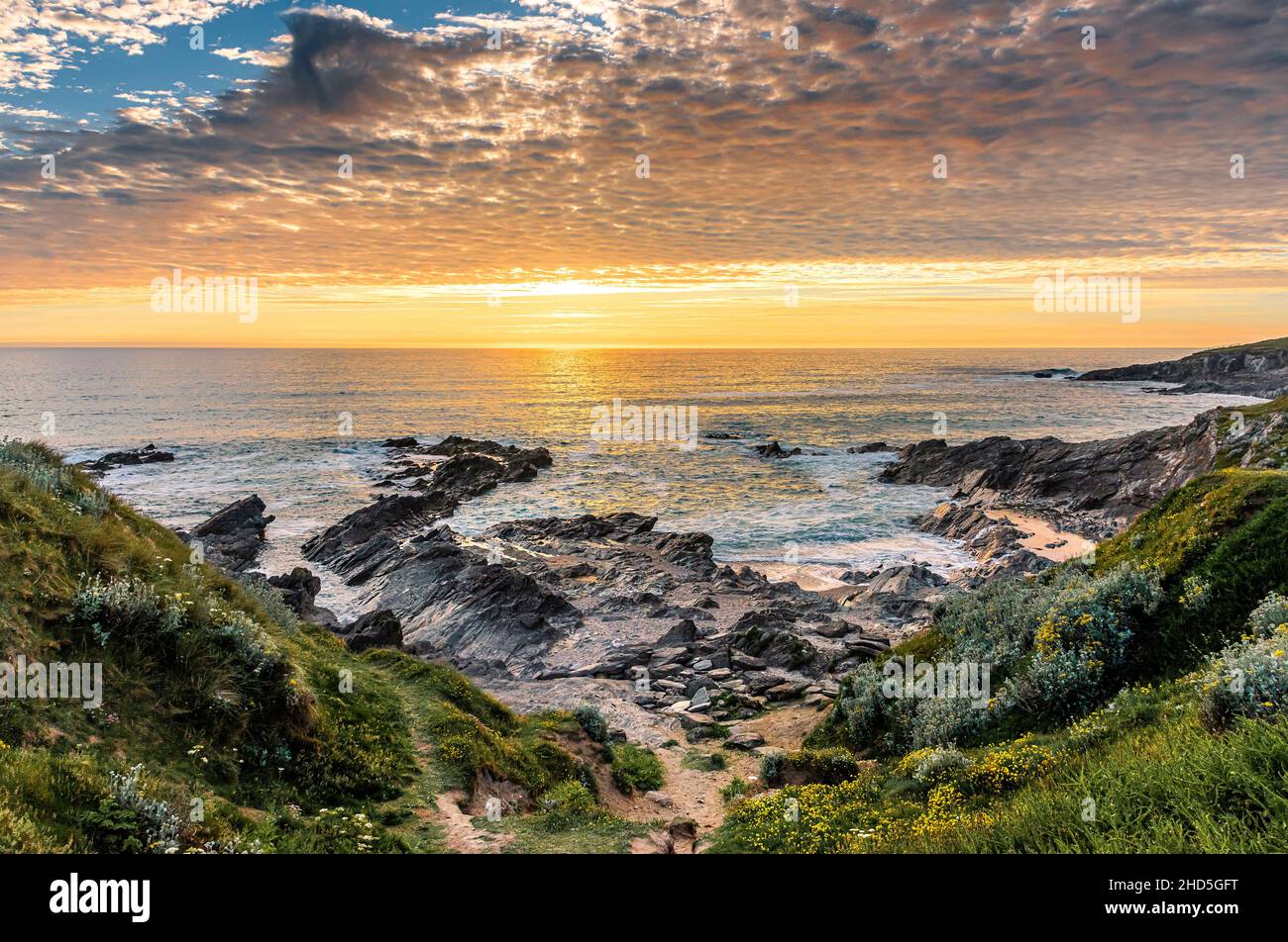 Ein wunderschöner, farbenfroher Sonnenuntergang über Little Fistral an der Küste von Newquay in Cornwall. Stockfoto