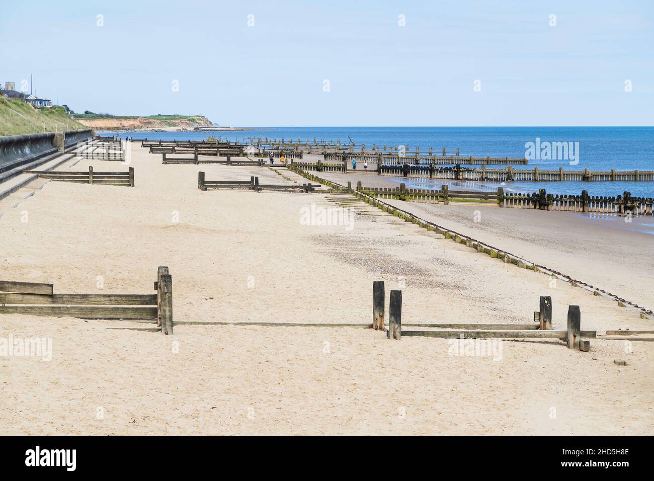 Am Strand von Cart Gap an der Küste von North Norfolk säumen hölzerne Groynes. Stockfoto