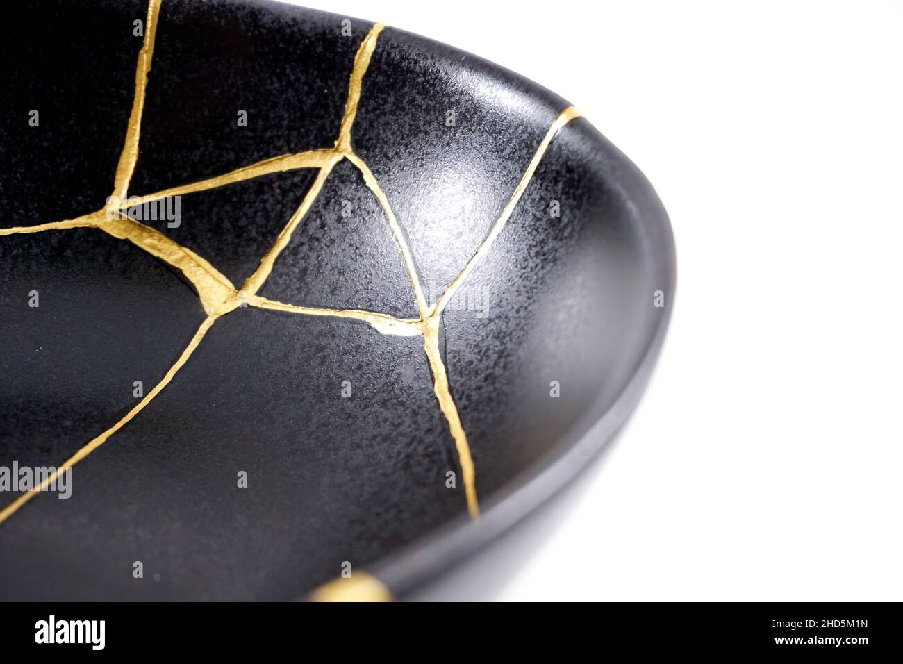Kintsugi Gold Risse Restaurierung, japanische schwarze Schale mit der antiken Kintsukuroi Restaurierung Technik, die Schönheit der Unvollkommenheiten, fixiert, darstellen Stockfoto