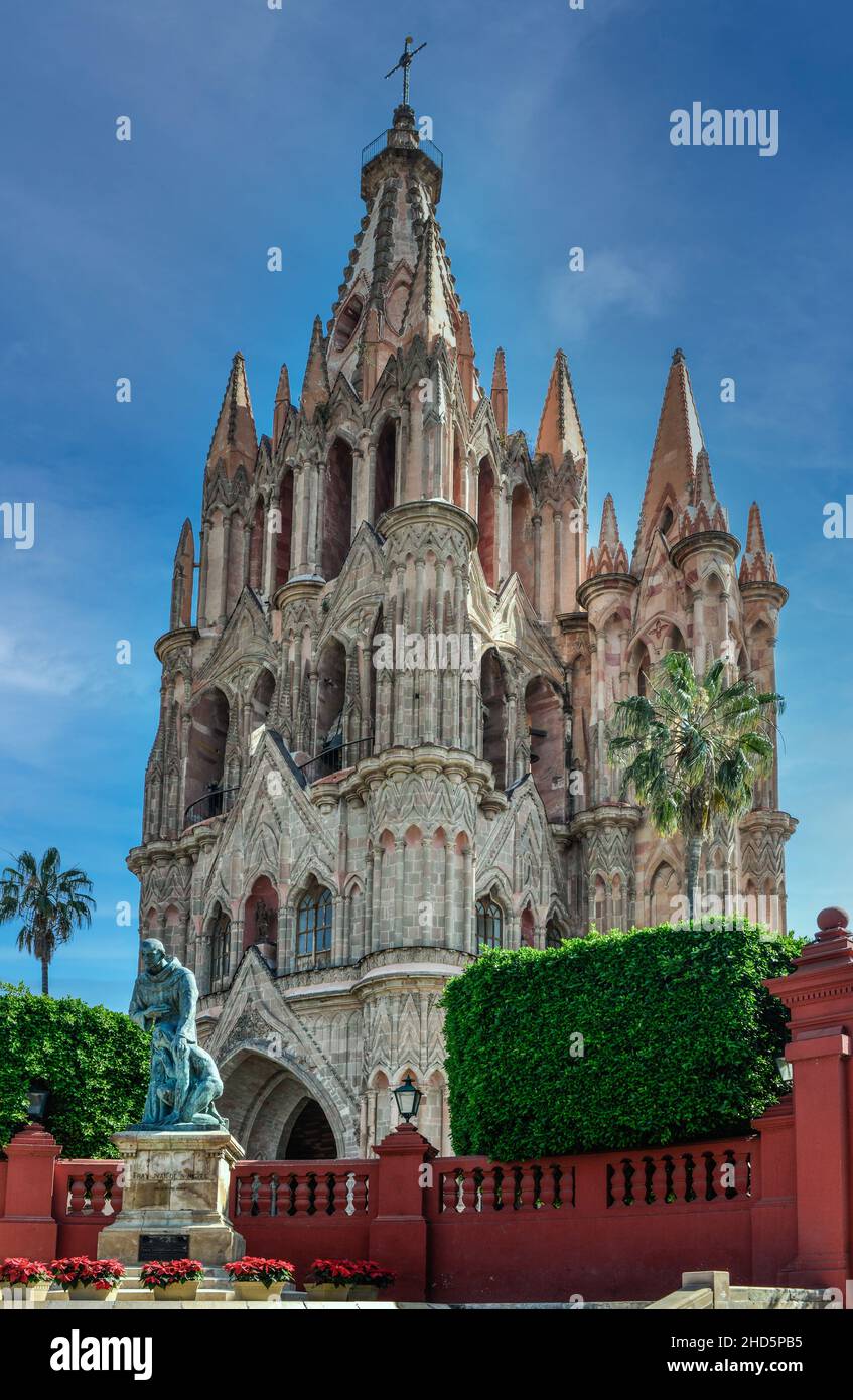 Blick auf die spektakuläre rosafarbene neugotische Kathedrale Parroquia de San Miguel aus dem 17th. Jahrhundert mit Statue von Fray Juan, San Miguel de Allen de, MX Stockfoto