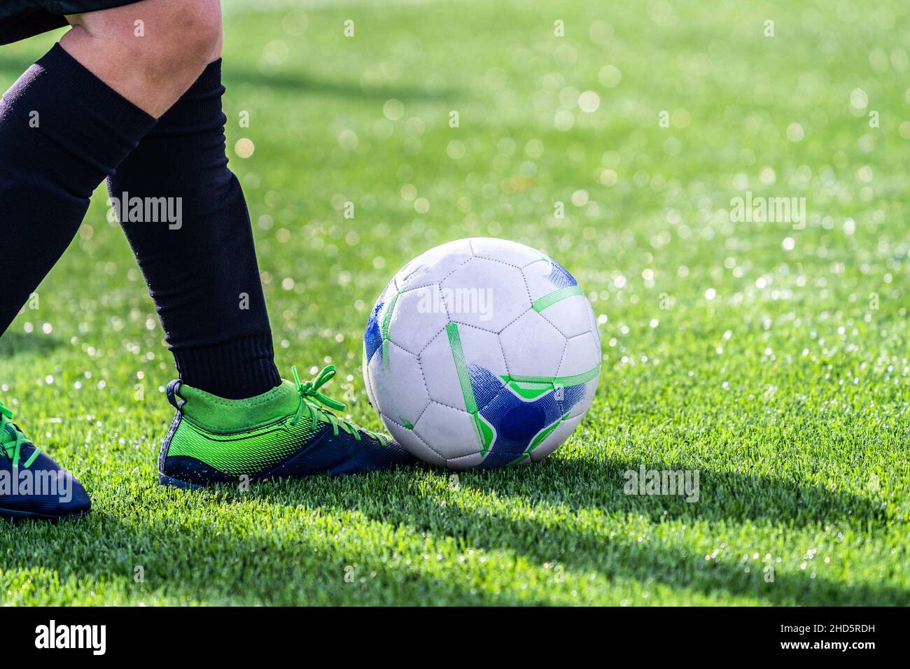 Nahaufnahme eines echten Amateurfußballspielers. Fußballspieler mit einem Ball, der auf dem Rasen des Fußballstadions spielt. Wettbewerb, Fußballschule, tou Stockfoto